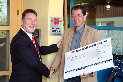 Detlef Tutas Mitarbeiter der Firma W&Uuml;RTH (v.l.) &uuml;berreicht den Spendencheck an S&ouml;ren Baumeister, Leiter der Werkstatt f&uuml;r behinderte Menschen