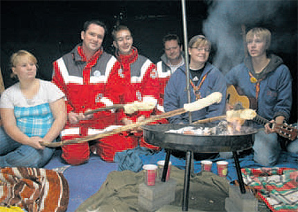 Gem&uuml;tliches Beisammensein im Zelt: Helfer von DRK und die Pfadfinder a&szlig;en gemeinsam mit den mitLeben- Besuchern Stockbrot auf dem Hof der Altschule in Bergen.