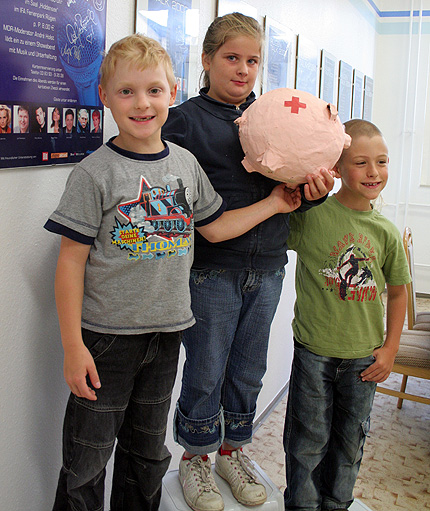 Max Szymanowski (7), Kassandra B&ouml;cker (9) und Maxemilia Mei&szlig;ner (7) sind Sch&uuml;ler der Klasse U2. Sie haben mit der Spenden das DRK Sparschwein gef&uuml;llt und warten nun auf die Sportger&auml;te.