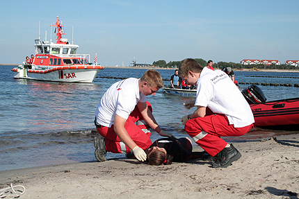 Tommy Scheel vom DRK Sanit&auml;tszug  und Thomas Schlanert vom Jugendrotkreuz (JRK) versorgen einen Leichtverletzten