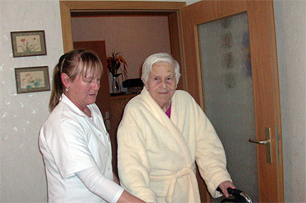 Pflegefachkraft Petra Neumann begleitet Frau Ilse Weihrich nach der K&ouml;rperpflege in die K&uuml;che.
