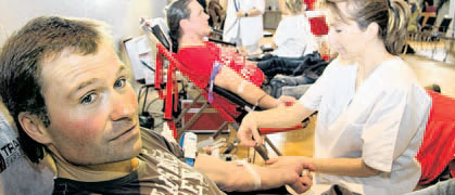 Schwester Anja von der Blutspendezentrale Stralsund zapft bei Matthias Nitsch die 50. Blutspende ab