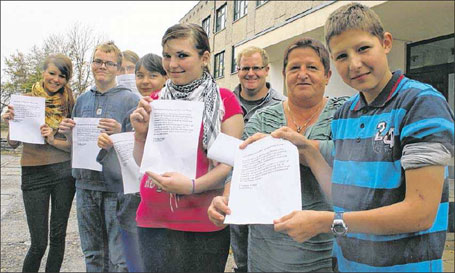 Schulleiterin Christine Porath und einige ihrer Schützlinge mit den Flugblättern, die sie im Ort verteilt haben.