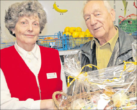 Dr. Klaus G&ouml;tz, stellvertretender Vorstandsvorsitzender des DRK-Kreisverbandes, &uuml;berreicht Helga Petersdorf einen gro&szlig;en Pr&auml;sentkorb zum Abschied